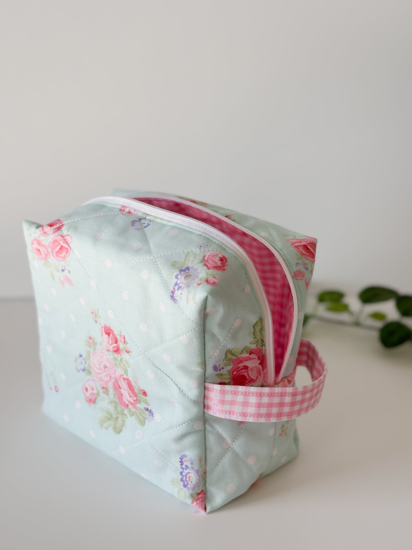 Handmade quilted makeup bag with aqua-blue background and pink rose floral print