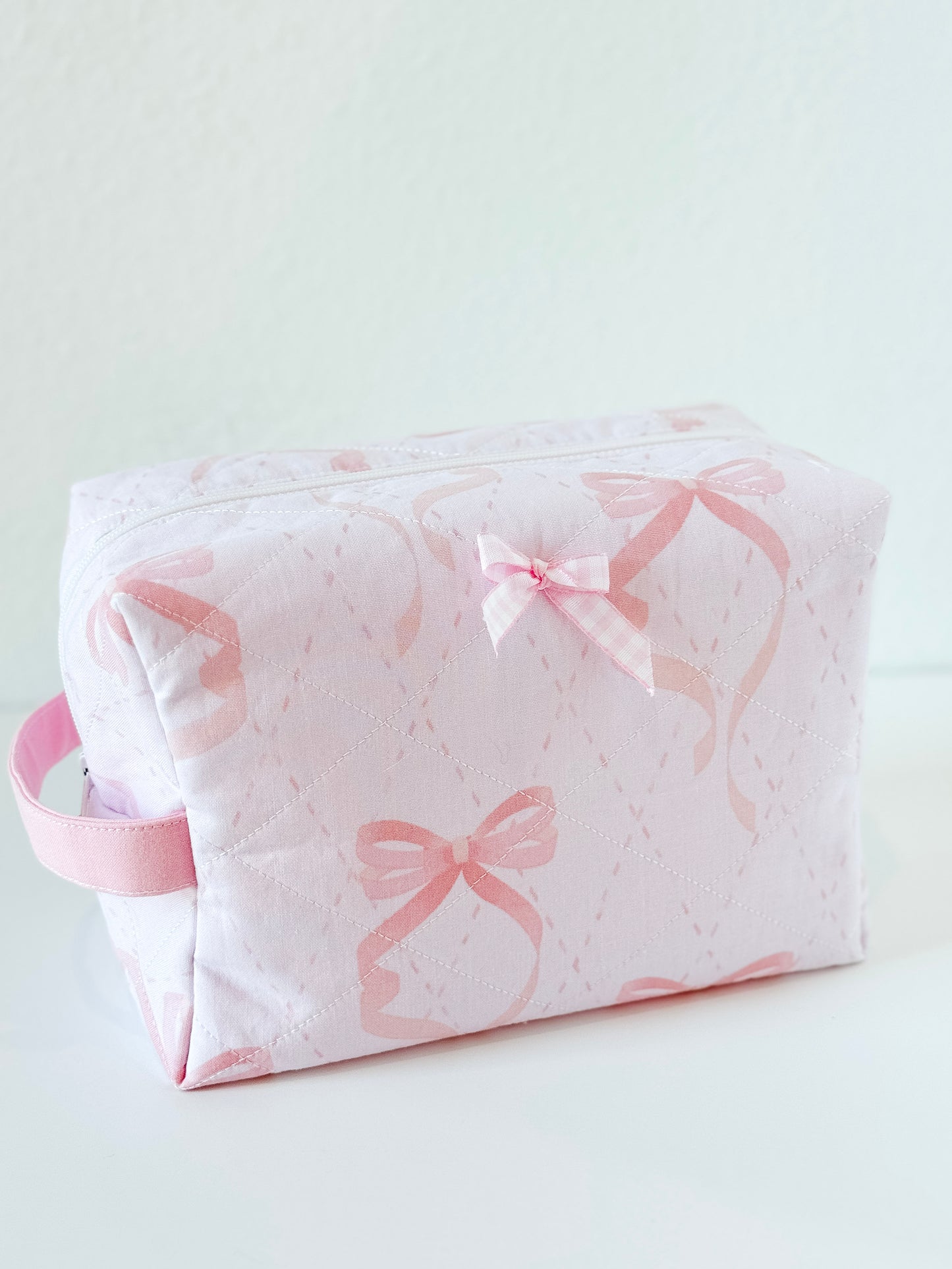 Handmade quilted makeup bag in pale pink with bow print