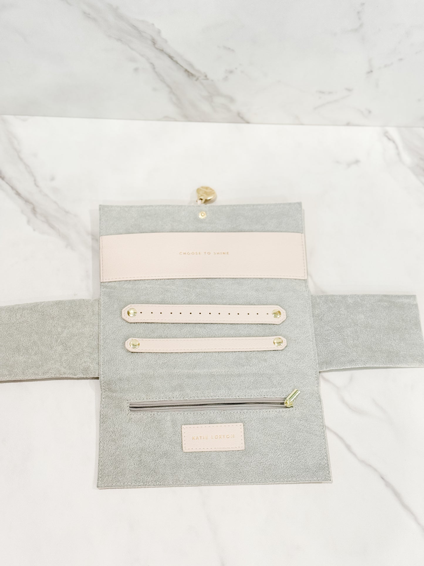 Showcasing the inside of our Katie Loxton vegan leather jewelry travel pouch in color eggshell