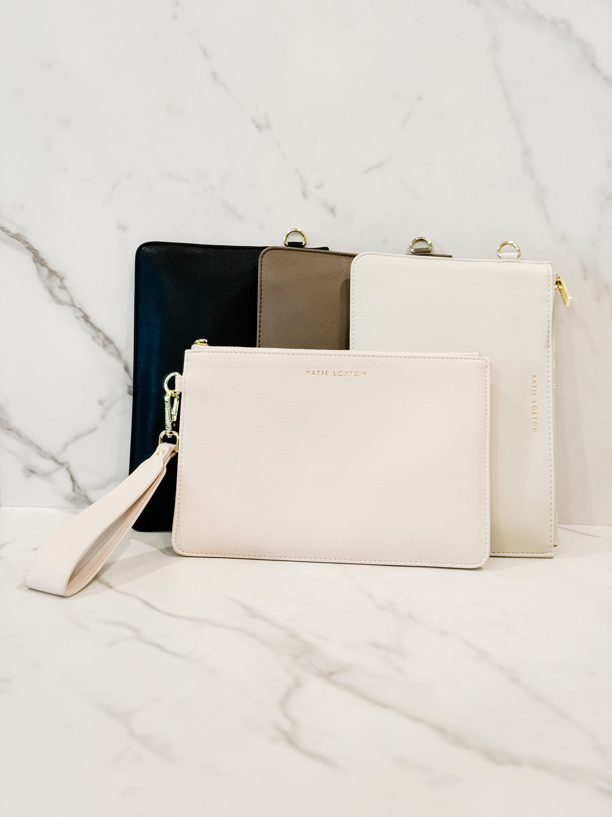 Katie Loxton Zana wristlet pouch in a vegan leather with gold zip featuring the colors mink, eggshell, black and cream