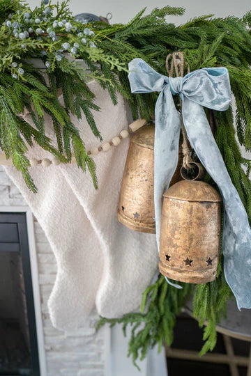 White bouclé Christmas stocking styled with neutral holiday décor