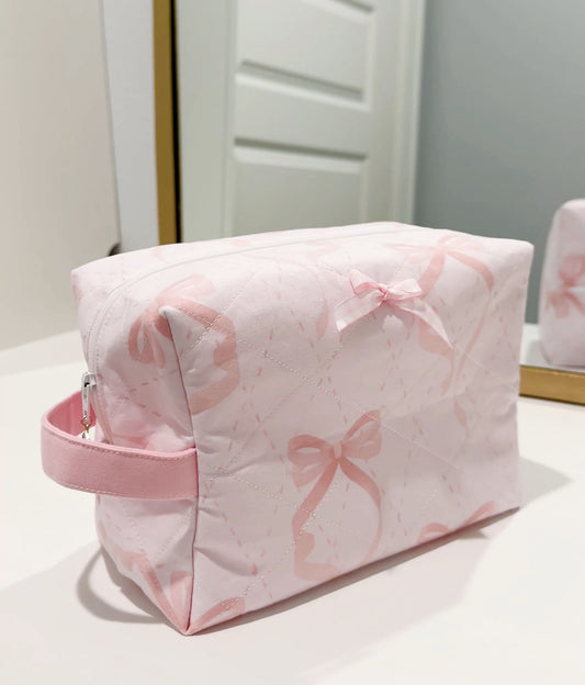 Handmade quilted makeup bag in pale pink with bow print