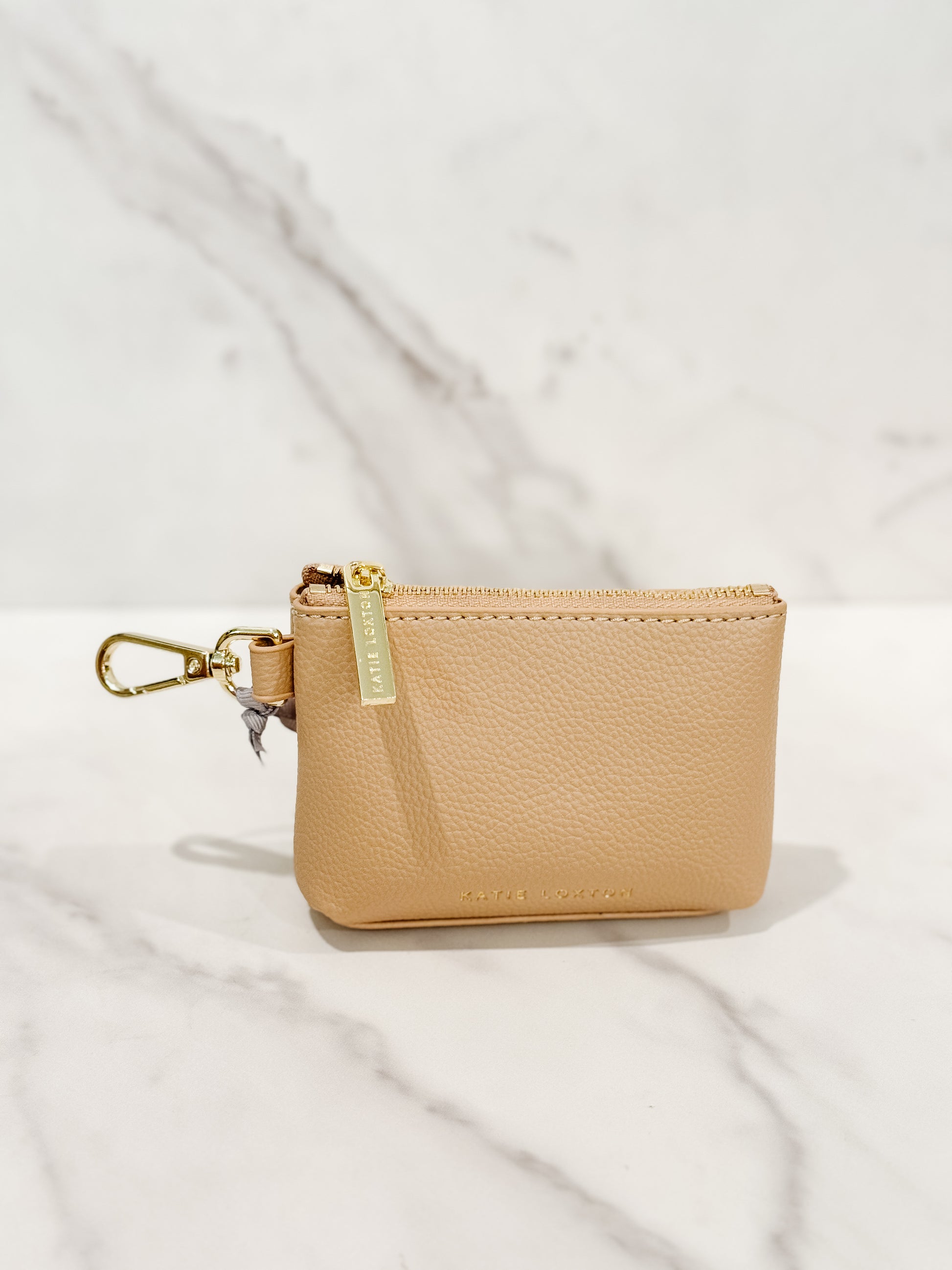 Evie clip-on coin purse in soft tan, small and compact design with gold clasp, perfect for keeping coins, cash, and essentials organized.