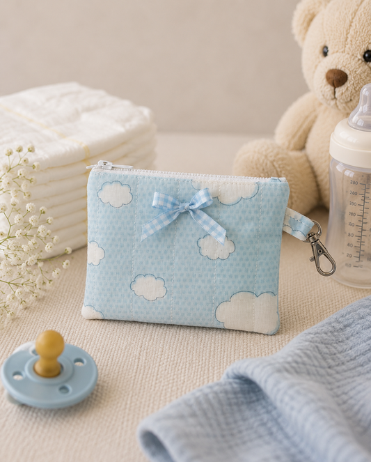 Blue Skies quilted coin purse with soft blue cloud print and coordinating attachment loop, styled with everyday baby essentials.