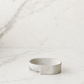 Minimal handcrafted cement soap dish on a clean white marble surface with soft neutral lighting and modern luxury studio styling.