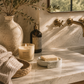 Minimal cement soap dish on creamy marble with sculptural travertine decor, flax linen, and soft neutral California modern styling.