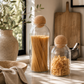 California coastal modern pantry featuring decorative glass storage jars with cork lids styled with natural textures and soft neutral decor