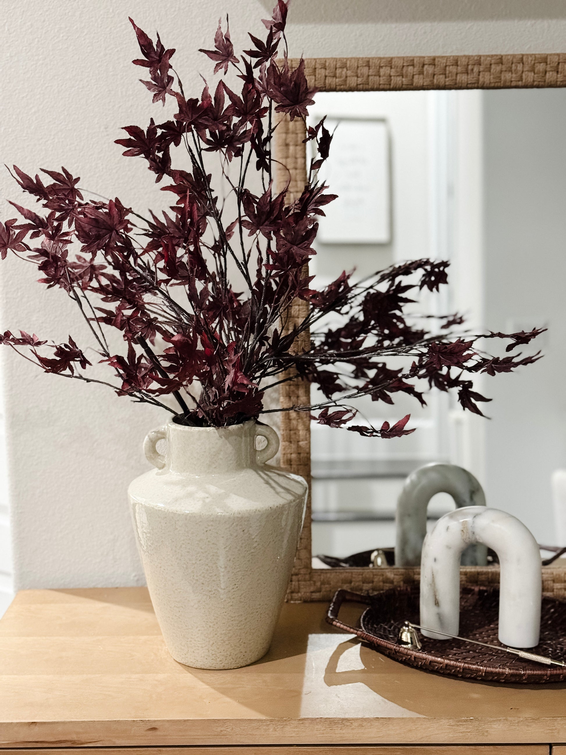 dark red maple leaf stem styled in vase with fall décor accents