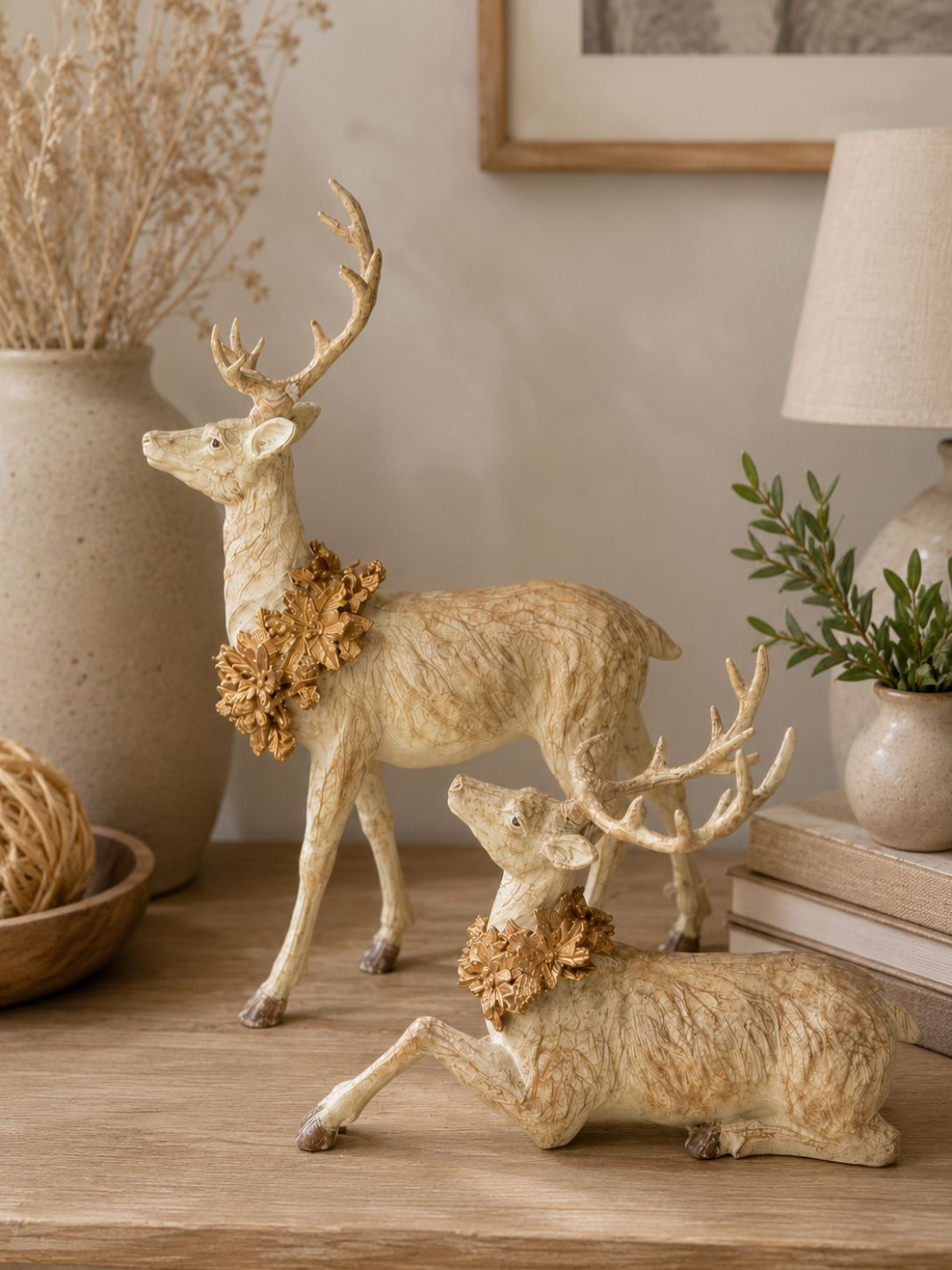 Resin faux wood grain deer with an antique gold wreath styled on a neutral Christmas console table.
