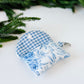 Gingham blue lined airpods case with floral blue blossom exterior.