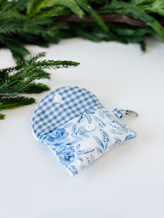 Gingham blue lined airpods case with floral blue blossom exterior.