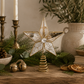 Gold mercury glass star tree topper with antiqued mirrored glass panels and crystal center styled on a reclaimed wood console with cedar greenery, brass candlesticks, pinecones, dried orange slices, and designer-inspired Christmas décor.