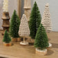 Green glittered bottle brush Christmas trees styled on holiday mantel