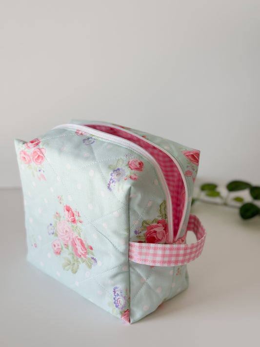 Handmade quilted makeup bag with aqua-blue background and pink rose floral print