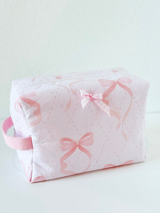 Handmade quilted makeup bag in pale pink with bow print