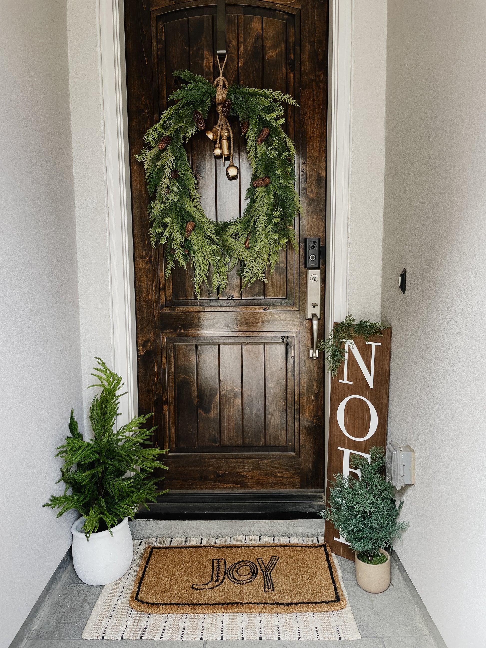 Creative Co-Op “Joy” doormat styled at front door with holiday greenery