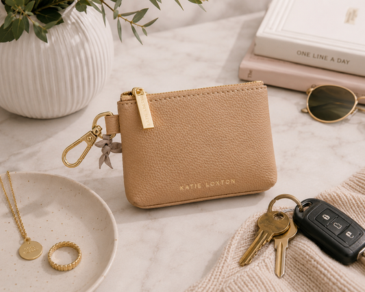 This alt text matches the styling of the image (keys, sunglasses, jewelry) and emphasizes the intended everyday use of the clip-on coin purse rather than makeup.