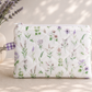 Lavender Meadows quilted medium wristlet pouch with wildflower print and purple gingham loop styled on a neutral tabletop with everyday accessories.