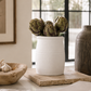 Matte white ceramic vessel styled with wooden kitchen utensils in warm California coastal modern kitchen