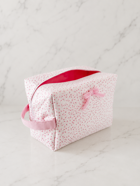 Pink floral boxy makeup bag on marble background in soft editorial studio lighting