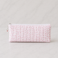 Pink floral quilted pencil case on white marble background in bright luxury studio lighting