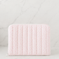 Pink floral quilted iPad sleeve on white marble background in soft neutral studio lighting