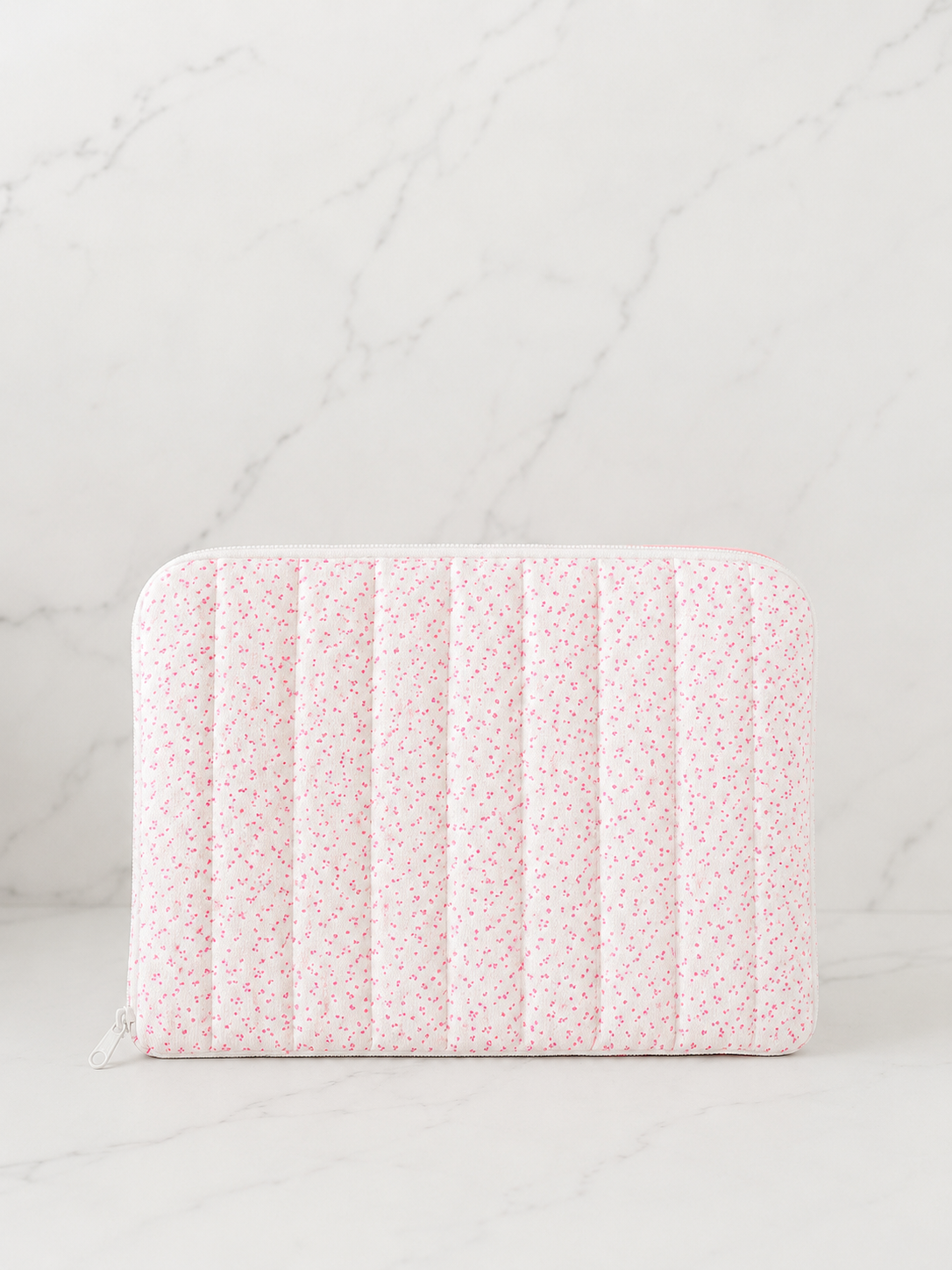 Pink floral quilted iPad sleeve on white marble background in soft neutral studio lighting