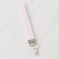 Pink floral fabric wristlet keychain with silver hardware and envelope charm on white marble studio background