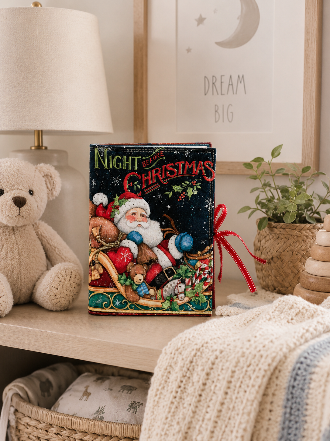 Quilted Night Before Christmas soft book styled on a nursery shelf with plush toys and neutral holiday décor.