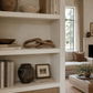 Rustic carved wood chain link decor displayed on a modern living room bookshelf with warm neutral styling and soft luxury interiors.