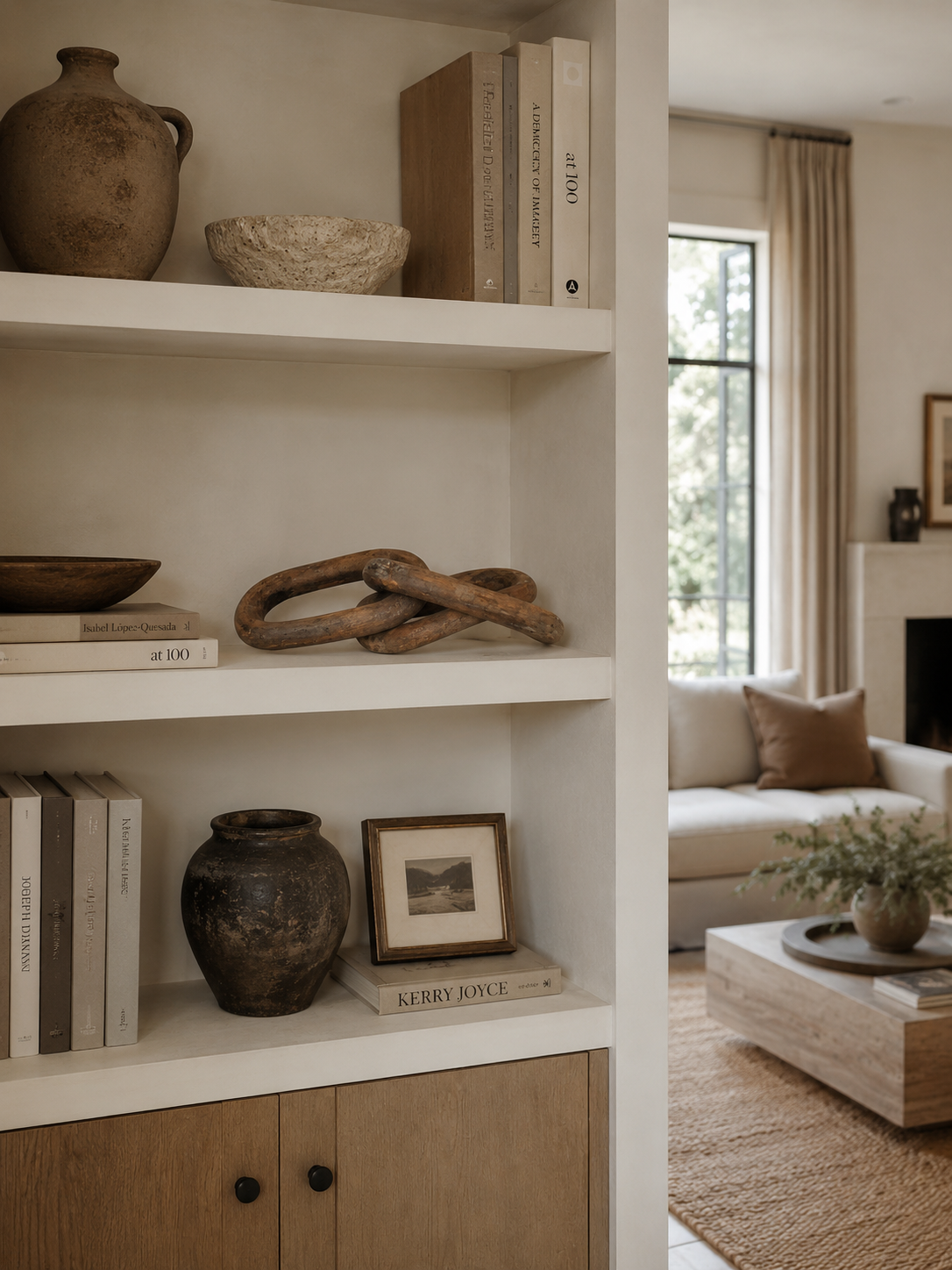 Rustic carved wood chain link decor displayed on a modern living room bookshelf with warm neutral styling and soft luxury interiors.