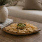 Wood chip and dip serving platter with brass bowl styled on a coffee table with tortilla chips, guacamole, and cocktails in a modern California-inspired living room.