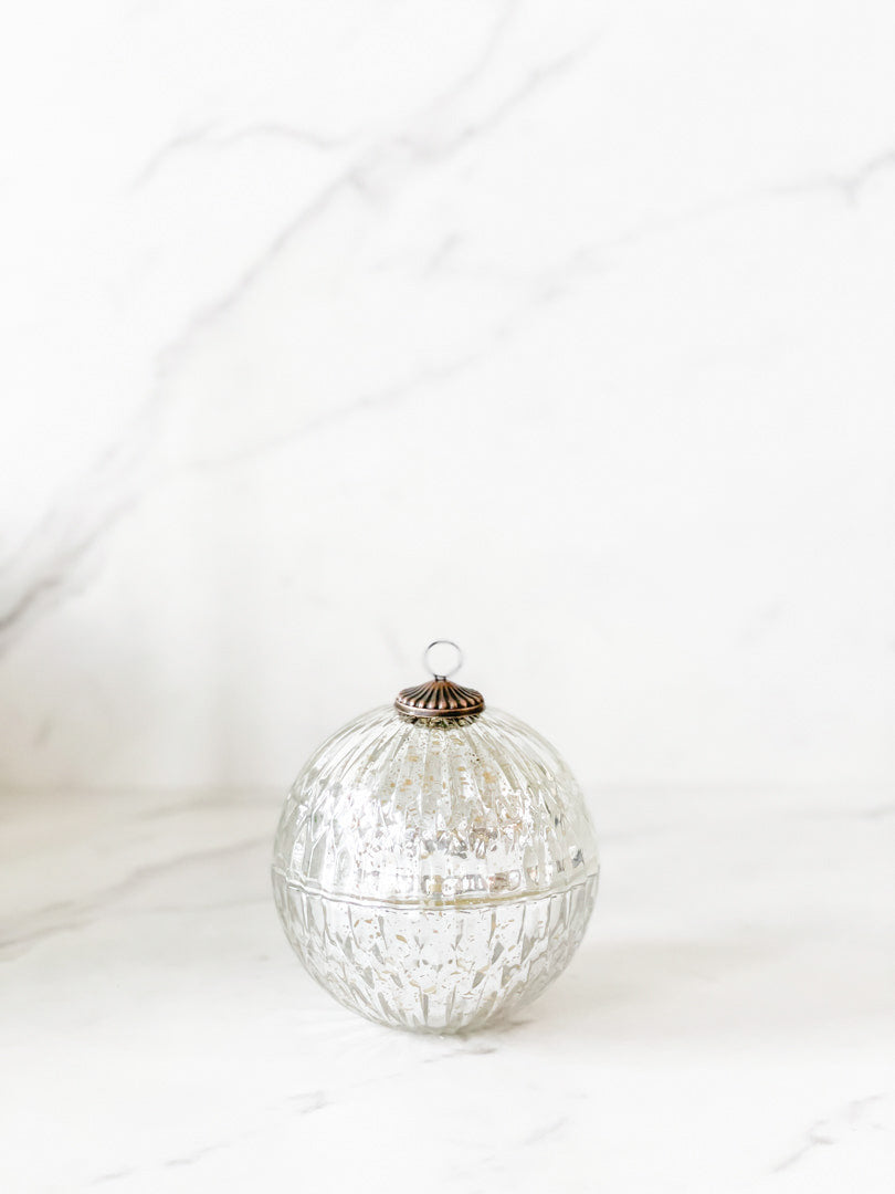 Silver mercury glass ornament-shaped candle with a luxurious blend of balsam, cedar, cinnamon, oak moss, and eucalyptus, hand-poured in a decorative silver vessel perfect for holiday decor and gifting.