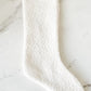 Close-up of white bouclé texture and cozy knit weave on holiday stocking